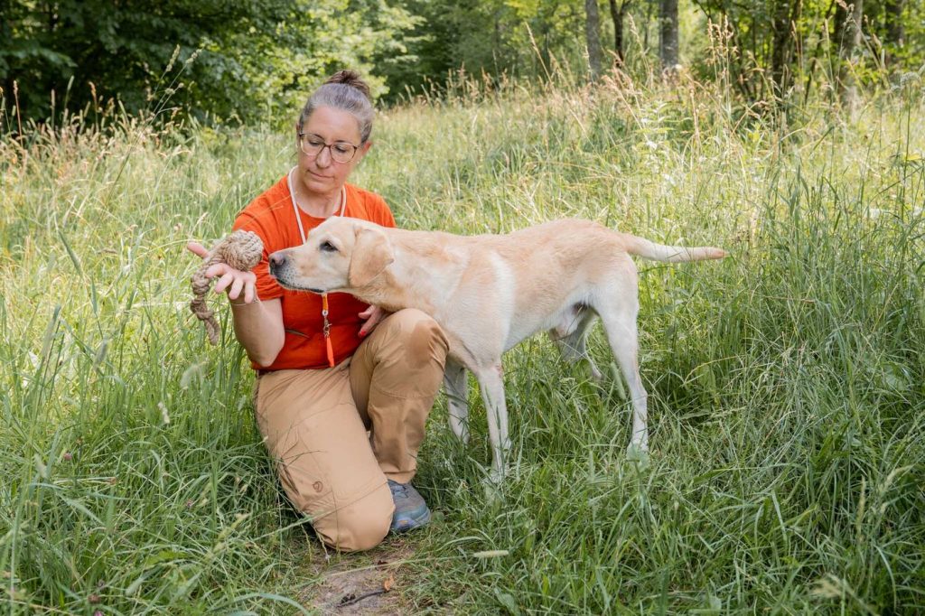 Corinna-Helen Wilhelm beim Training mit Labrador Luke auf der Wiese